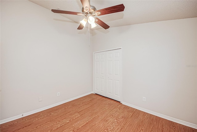 empty room with ceiling fan, lofted ceiling, and light hardwood / wood-style flooring