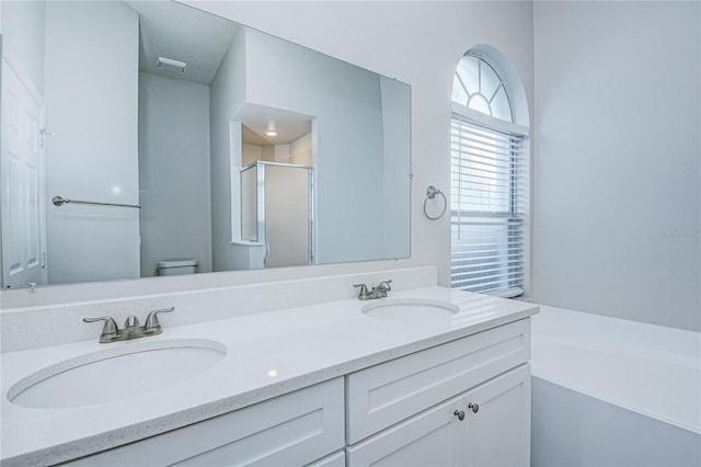 full bathroom featuring shower with separate bathtub, vanity, and toilet