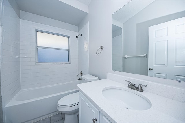 full bathroom featuring tiled shower / bath, vanity, and toilet