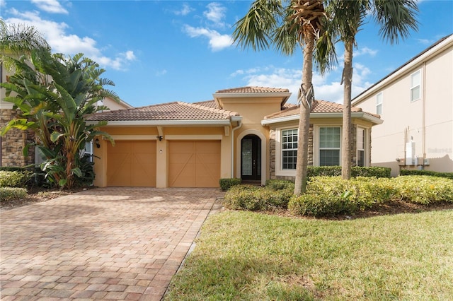 mediterranean / spanish home with a front yard and a garage