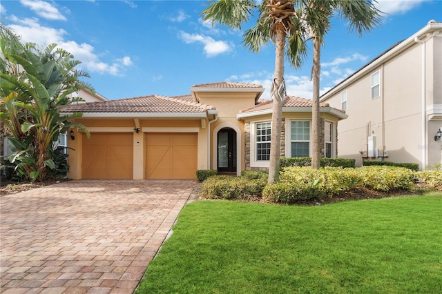 mediterranean / spanish-style house featuring a garage and a front lawn