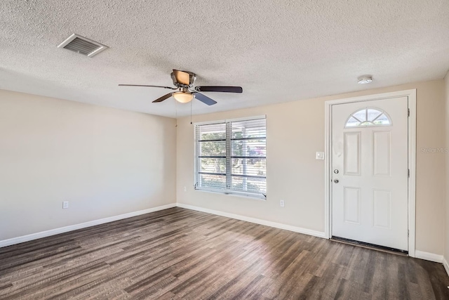 foyer entrance featuring ceiling fan, dark wood-type flooring, a healthy amount of sunlight, and a textured ceiling