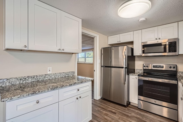 kitchen featuring white cabinetry, stainless steel appliances, and a textured ceiling