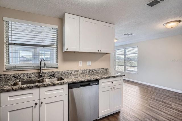 kitchen featuring dishwasher, white cabinets, a textured ceiling, and sink