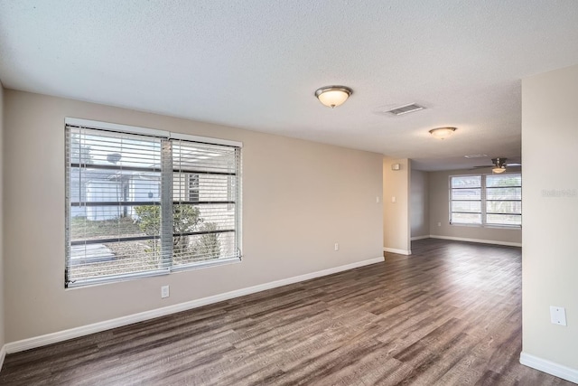 unfurnished room featuring ceiling fan, dark hardwood / wood-style floors, and a textured ceiling