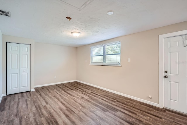 spare room featuring hardwood / wood-style floors and a textured ceiling