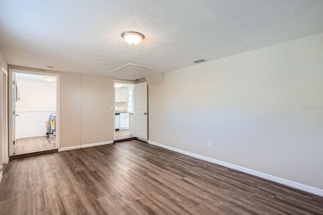 empty room with a textured ceiling and dark wood-type flooring