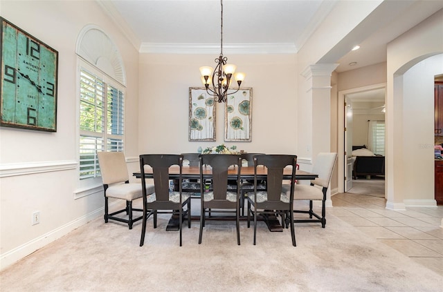 dining space featuring light carpet, a chandelier, ornate columns, and crown molding