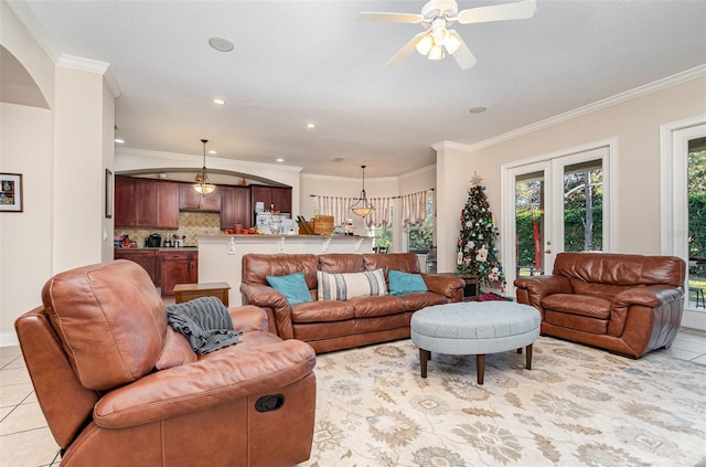 tiled living room with ceiling fan, french doors, and ornamental molding