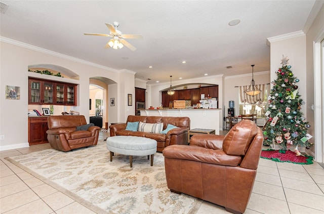 tiled living room featuring ceiling fan and ornamental molding