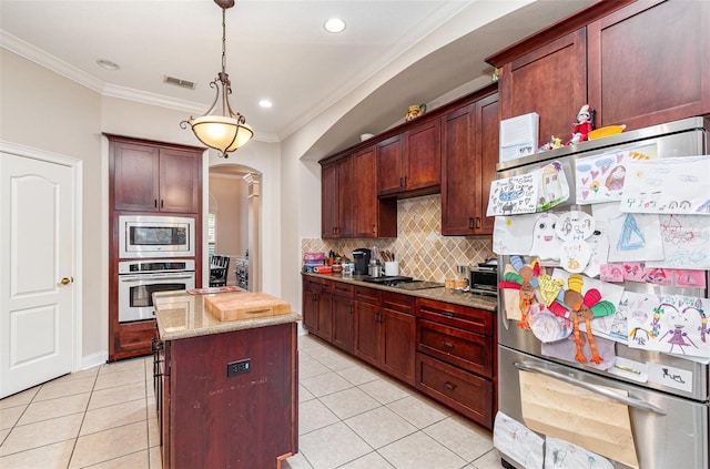 kitchen featuring a center island, light stone counters, decorative light fixtures, decorative backsplash, and appliances with stainless steel finishes