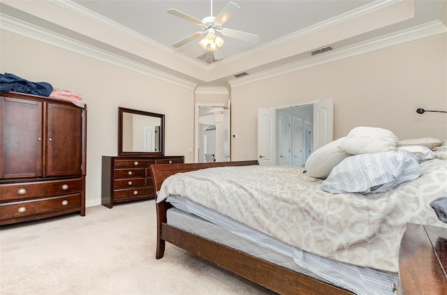 carpeted bedroom featuring ceiling fan, crown molding, and a tray ceiling