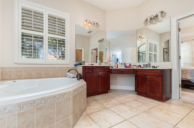 bathroom with tile patterned floors, tiled bath, and vanity