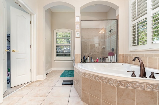 bathroom with tile patterned flooring and shower with separate bathtub