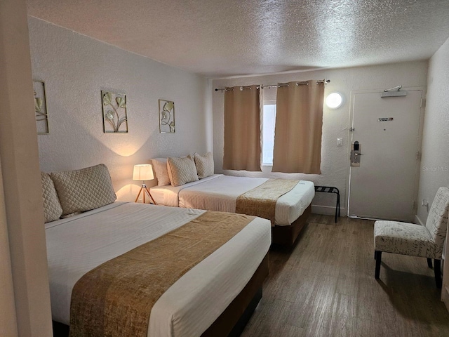 bedroom with wood-type flooring and a textured ceiling