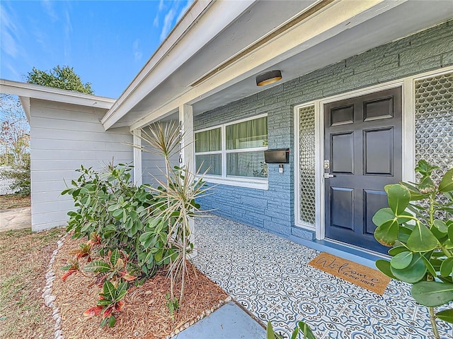 view of exterior entry featuring covered porch