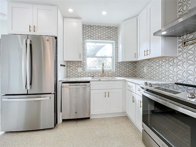 kitchen featuring decorative backsplash, stainless steel appliances, sink, wall chimney range hood, and white cabinets