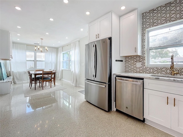 kitchen featuring a wealth of natural light, white cabinetry, sink, and stainless steel appliances