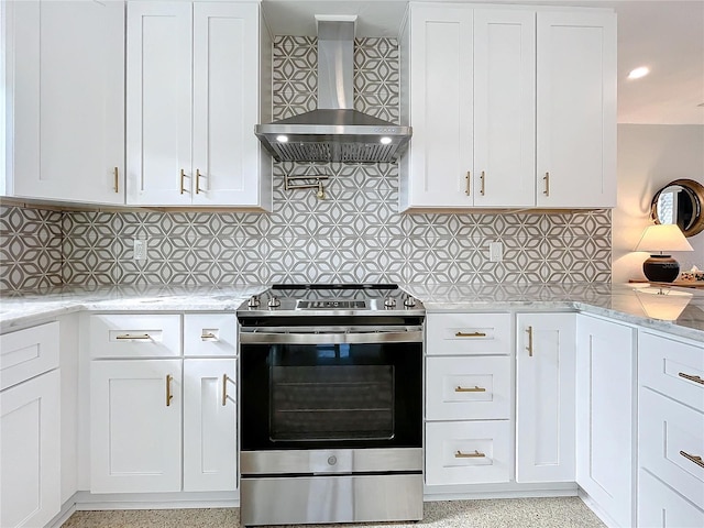 kitchen featuring wall chimney range hood, backsplash, white cabinetry, and electric stove