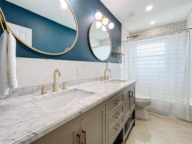 bathroom featuring vanity, tile walls, and toilet