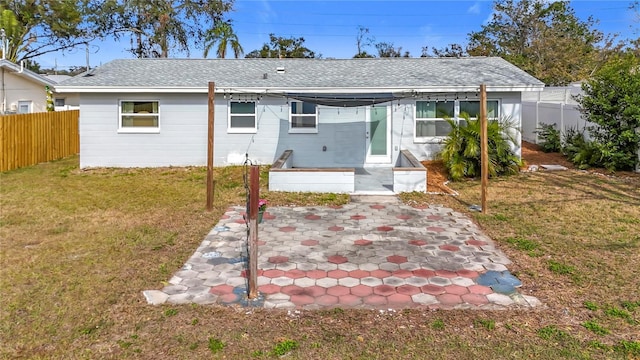 back of house featuring a lawn and a patio