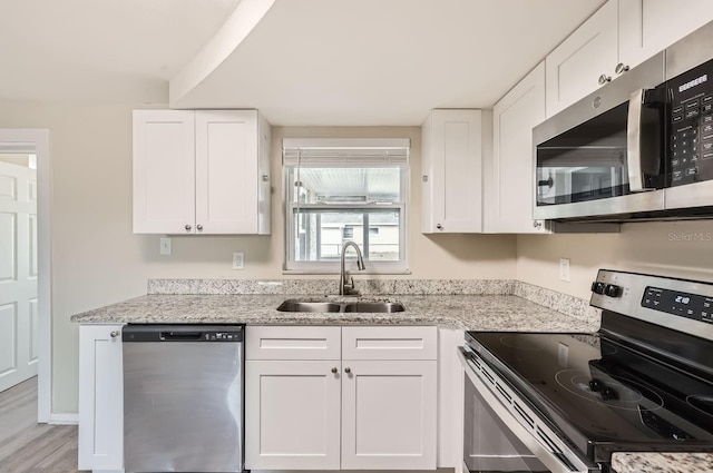 kitchen featuring sink, stainless steel appliances, and white cabinetry