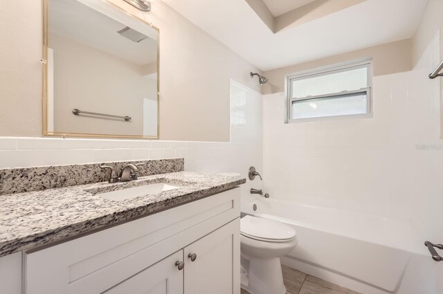 full bathroom with tile walls, backsplash,  shower combination, toilet, and vanity