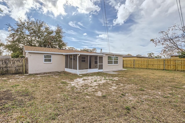 back of house with a lawn and a sunroom