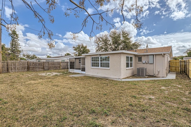 rear view of house featuring a sunroom, central AC, and a yard