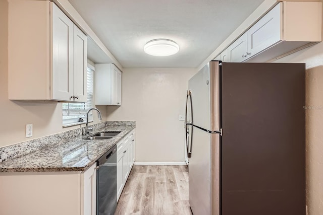 kitchen featuring light stone countertops, appliances with stainless steel finishes, sink, light hardwood / wood-style floors, and white cabinetry