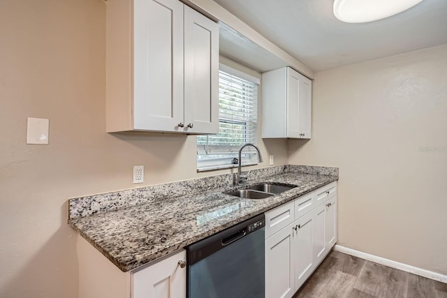 kitchen featuring dishwasher, white cabinets, sink, light wood-type flooring, and stone countertops