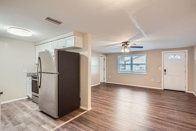 kitchen featuring white cabinets, ceiling fan, stainless steel appliances, and light hardwood / wood-style flooring