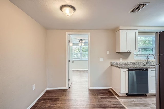 kitchen with dishwasher, light stone countertops, white cabinetry, and plenty of natural light