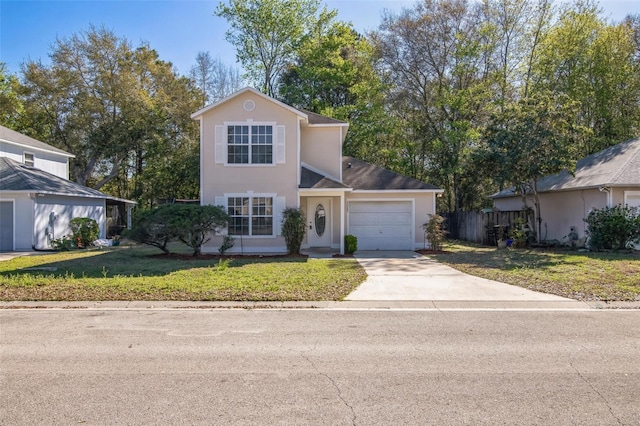 traditional-style house featuring a garage, a front yard, driveway, and stucco siding