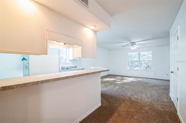 kitchen with baseboards, ceiling fan, light countertops, freestanding refrigerator, and dark colored carpet