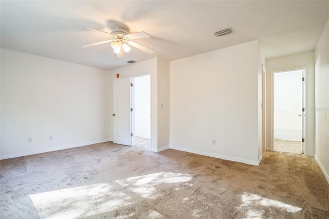 carpeted spare room with a ceiling fan, baseboards, and visible vents