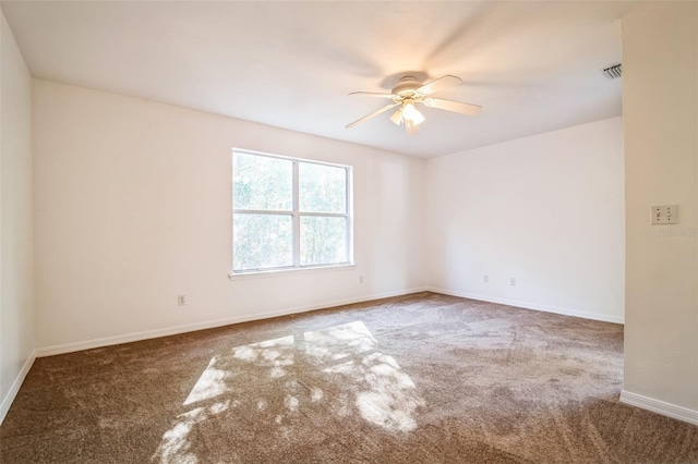 carpeted empty room with a ceiling fan, baseboards, and visible vents