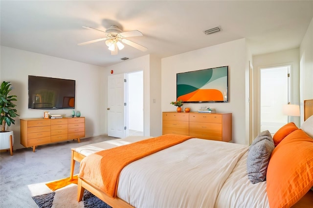 bedroom with a ceiling fan, light colored carpet, and visible vents