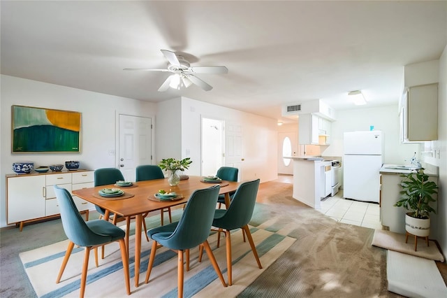 dining space with light tile patterned floors, visible vents, light colored carpet, and a ceiling fan