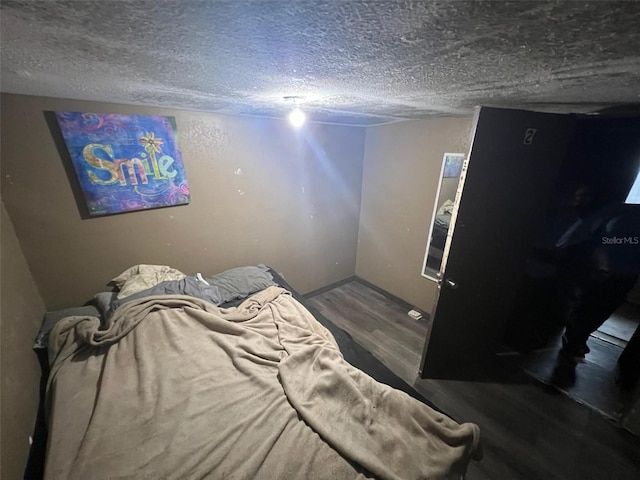 bedroom featuring a textured ceiling and hardwood / wood-style flooring