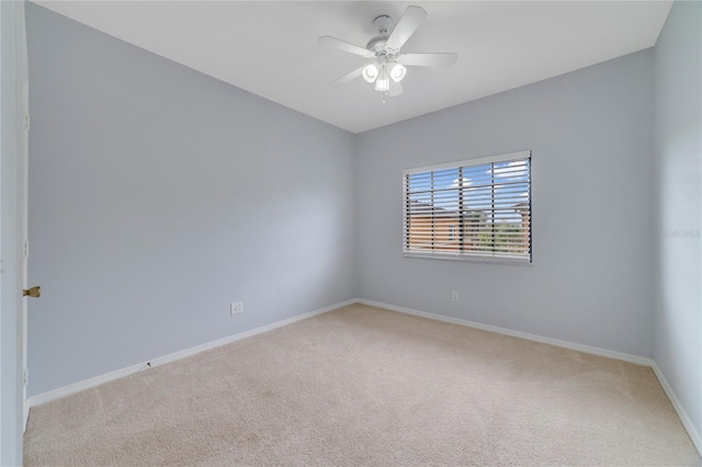 carpeted spare room with ceiling fan