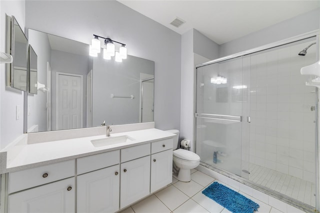 bathroom with tile patterned floors, vanity, toilet, and a shower with door