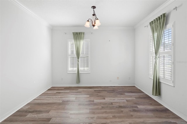 unfurnished room featuring crown molding, hardwood / wood-style floors, and a chandelier