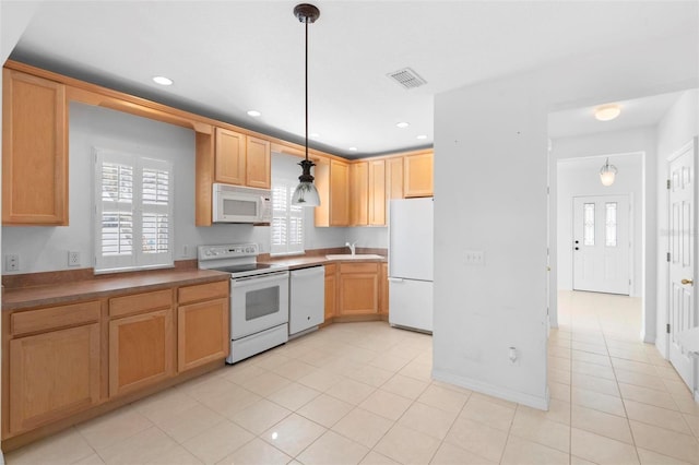 kitchen featuring light tile patterned flooring, sink, white appliances, and hanging light fixtures