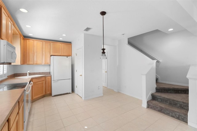 kitchen featuring pendant lighting, white appliances, sink, light tile patterned floors, and light brown cabinetry