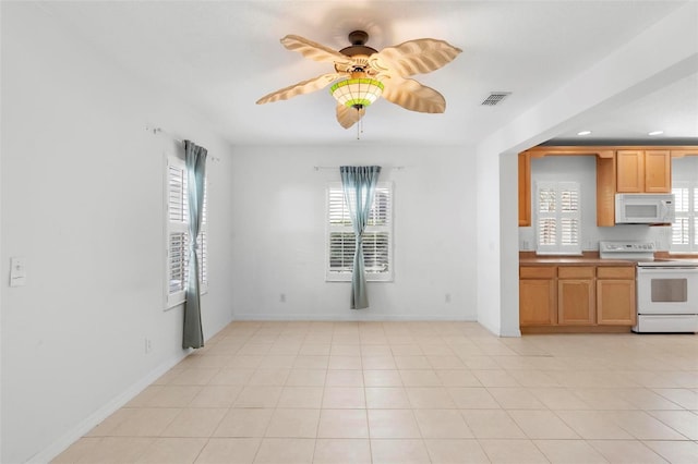 kitchen with plenty of natural light, white appliances, and light tile patterned floors