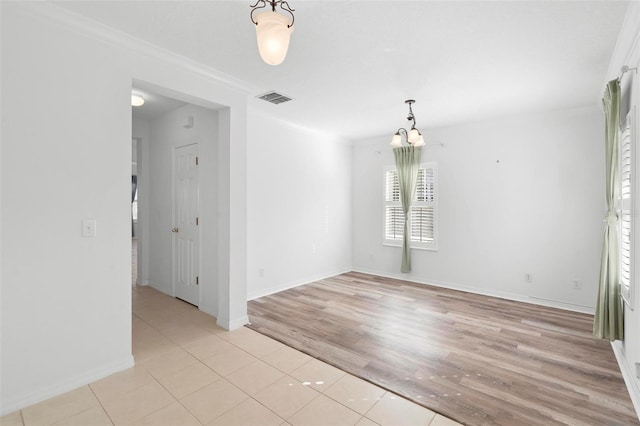 unfurnished room featuring light wood-type flooring, an inviting chandelier, and ornamental molding