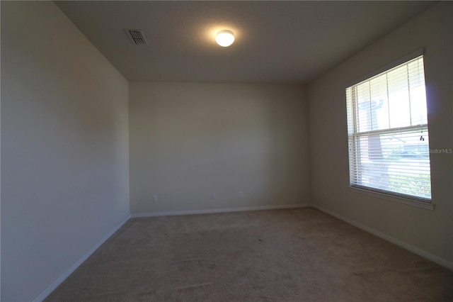 spare room featuring dark colored carpet