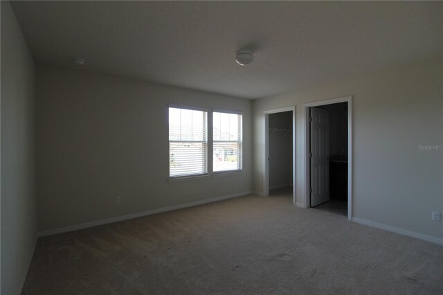 684 Bishop Bay Loop, Apopka, FL 32712 - unfurnished bedroom featuring light colored carpet and two closets