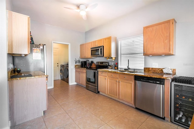 kitchen featuring sink, wine cooler, washing machine and dryer, light tile patterned flooring, and stainless steel appliances